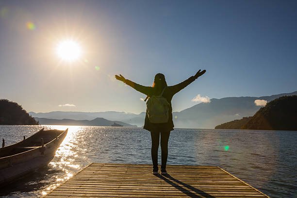 istock woman standing on pier by the lake 638451614