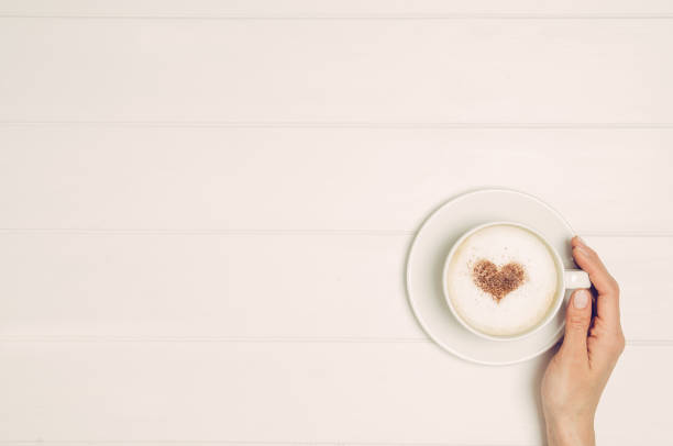 istock Female hand holding cup of coffee on table, top view 638452412
