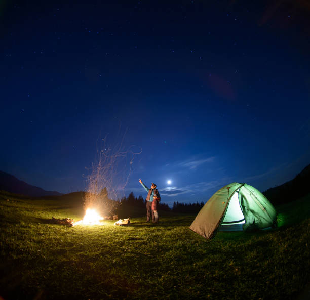 夜空の下でキャンプファイヤーとテントの近くの父と息子 - camping family nature tent ストックフォトと画像