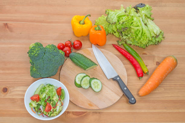 istock Chopped salad and whole fresh vegetables on wooden table. 638454782