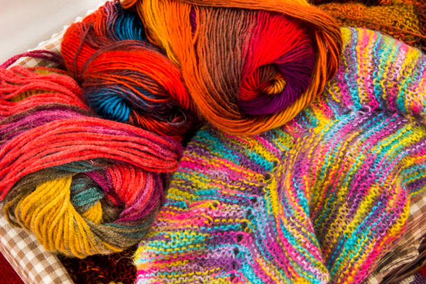 Colorful skeins of wool and wood needles in knitting basket stock photo
