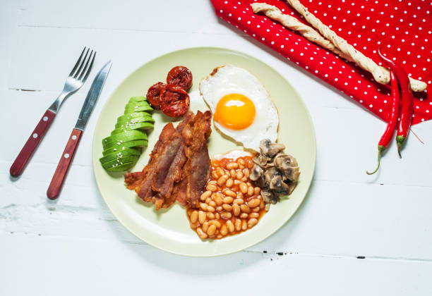 istock English breakfast of bacon, fried egg, beans, mushrooms, avocado 638458666