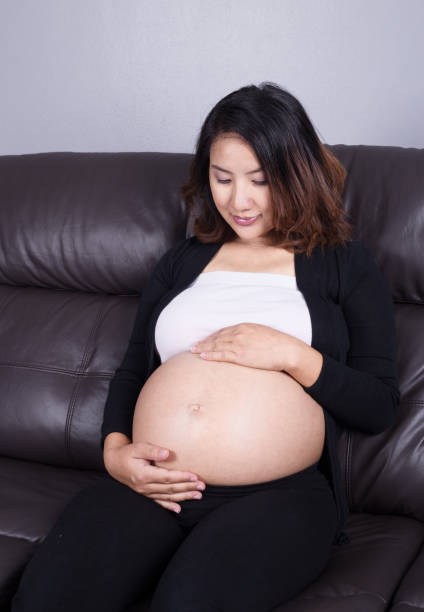 istock pregnant woman resting at home on sofa 638460426