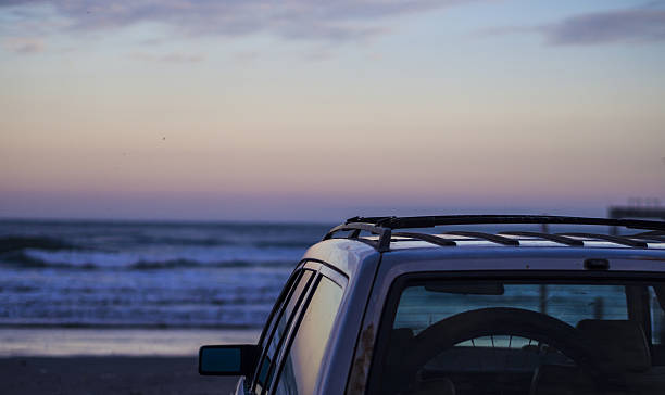 istock Parked car on the beach at sunset 638460980