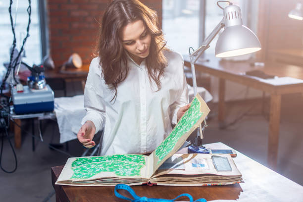 istock Pretty female tailor choosing a fabric in cloths catalog in 638461064