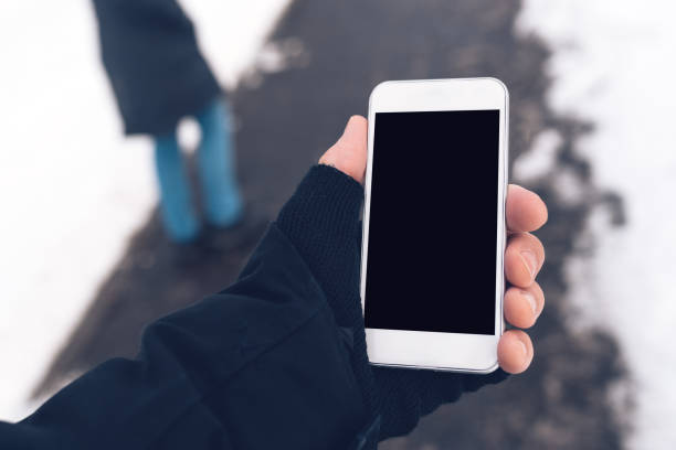 istock Mobile phone and male hands with winter gloves 638461392