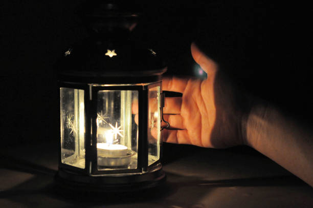 istock Hand illuminated wirt light from candle lantern in dark 638465858