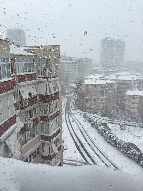 istock drops on window against city view under snow 638466776