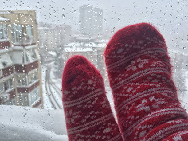 istock Feet in wool socks against street view under snow 638466858
