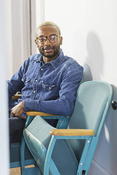 istock Young man with nose ring sitting in office 638468536