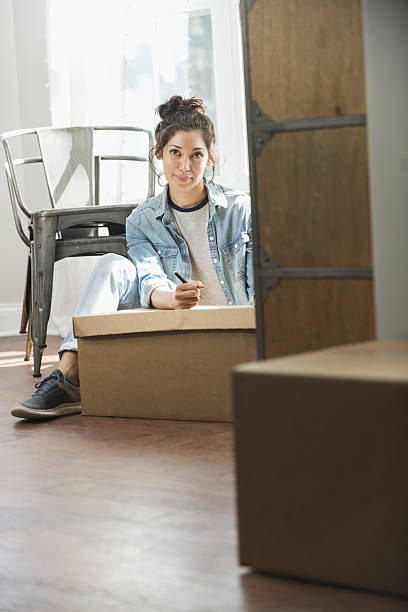 istock Young mixed race woman moving, writing checklist 638469994