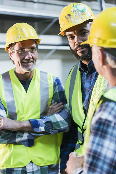 istock Three multi-ethnic workers with safety vests and hard hats 638470156