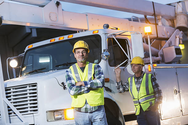 istock Two workmen in safety vests with truck 638470332