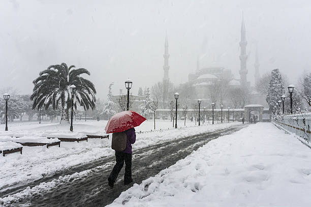 Woman walk on a snowy winter day in the historic Sultanahmet district of Istanbul, Turkey.