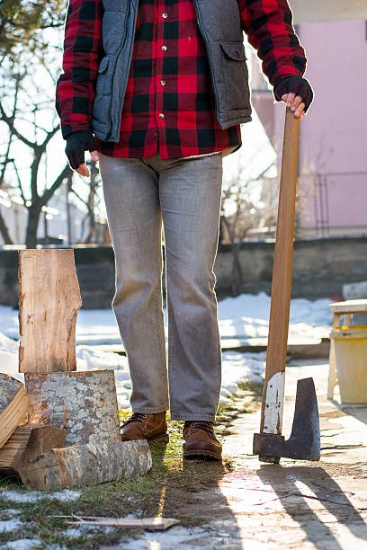 istock Man holding an axe for chopping firewood 638474814