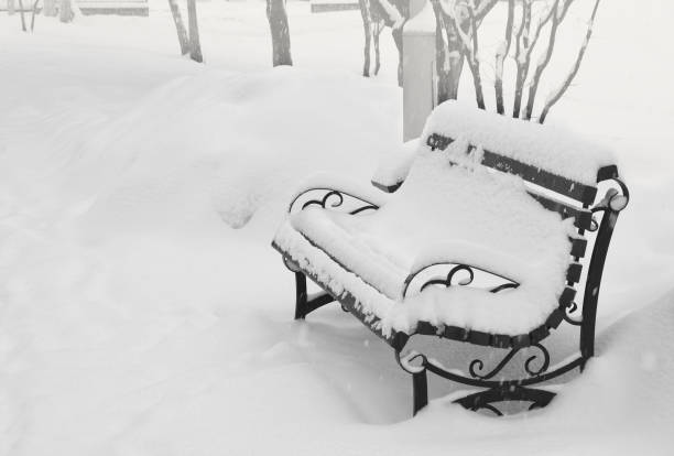 Snow on the street, large snowdrifts on the road, bench