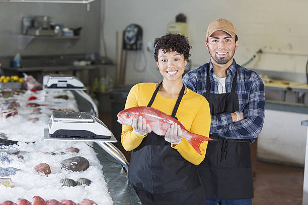 istock Young mixed race couple working in fish market 638480458