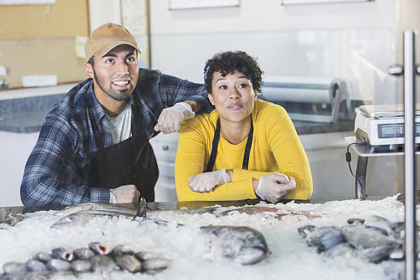 Young mixed race couple working in fish market
