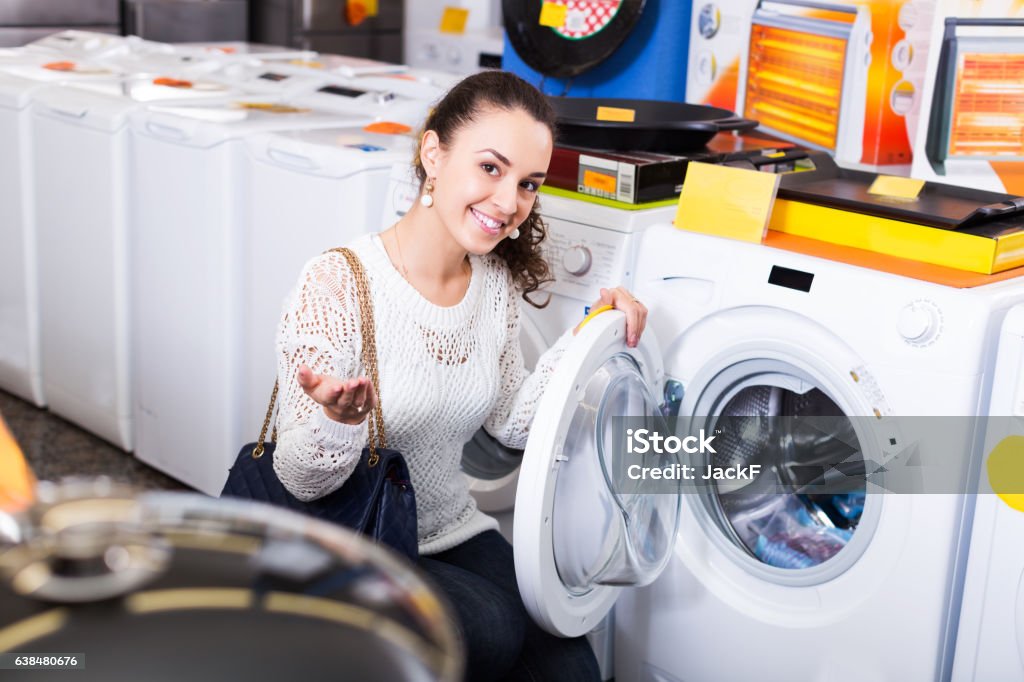 Customer looking at washers Average young customer looking at washers and dryers in store 20-29 Years Stock Photo