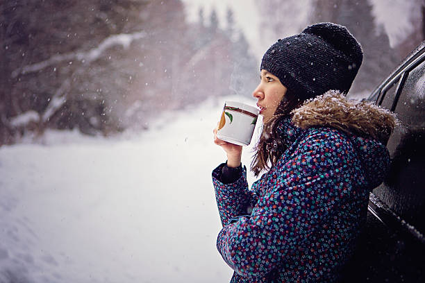 istock Girl is drinking hot tea in the snowy forest 638481028