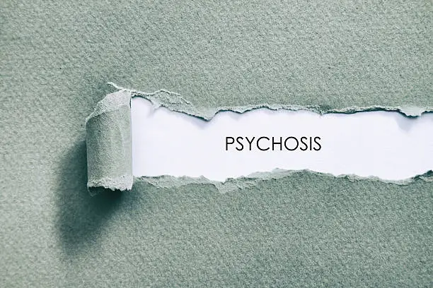 Psychosis word written under torn paper.