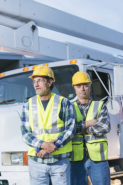 istock Two workmen in safety vests with truck 638482150