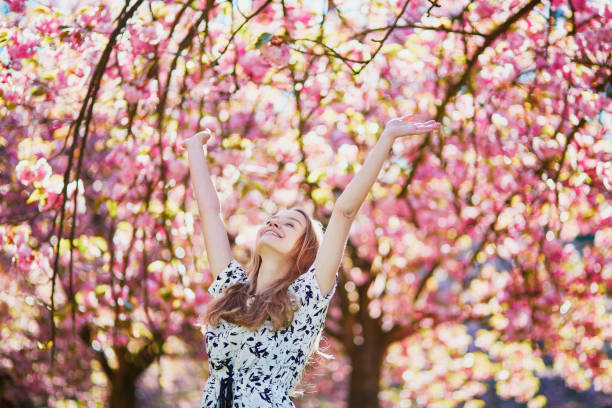 istock Beautiful young woman in blooming spring park 638482872
