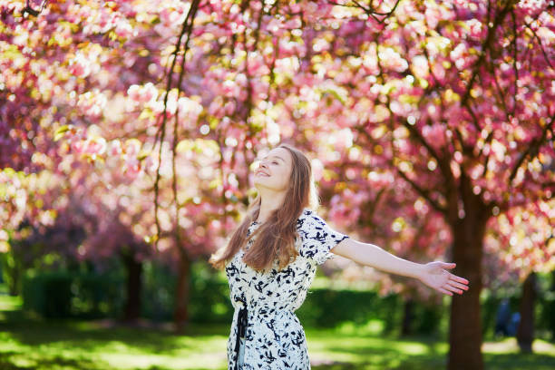 istock Beautiful young woman in blooming spring park 638482908