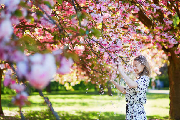 istock Beautiful young woman in blooming spring park 638483208