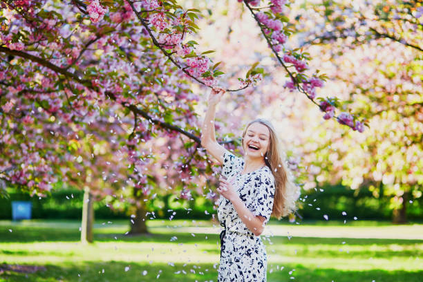 istock Beautiful young woman in blooming spring park 638483296