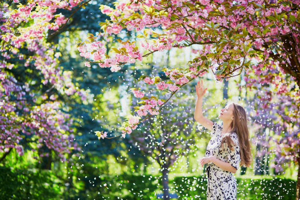 istock Beautiful young woman in blooming spring park 638483416