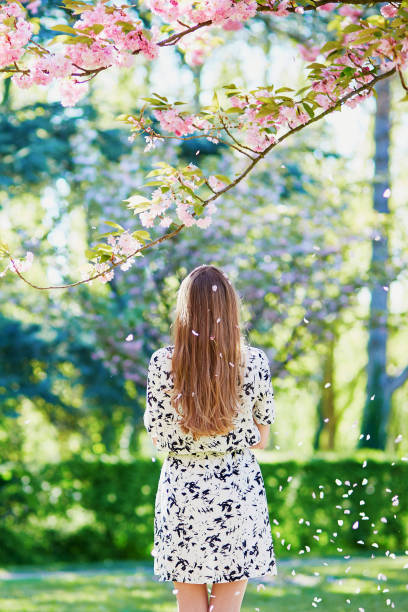 istock Beautiful young woman in blooming spring park 638483464