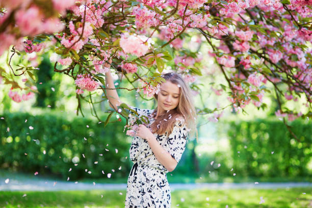 istock Beautiful young woman in blooming spring park 638483774