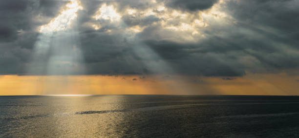 istock Sun's beam through heavy sky over the sea 638485186