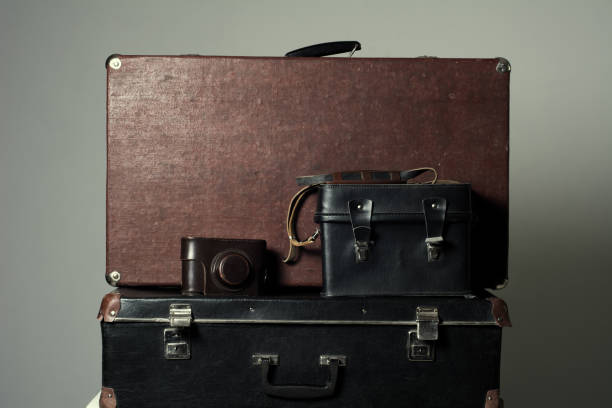 istock Background stack of old shabby suitcases and the camera 638486308