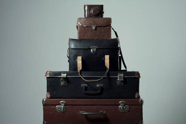 istock Background stack of old shabby suitcases and camera 638486370
