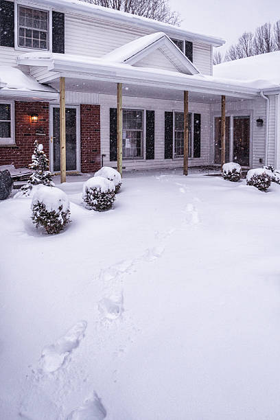 istock Deep Blizzard Snow Footprints Leading to Warm Home Entrance 638486532
