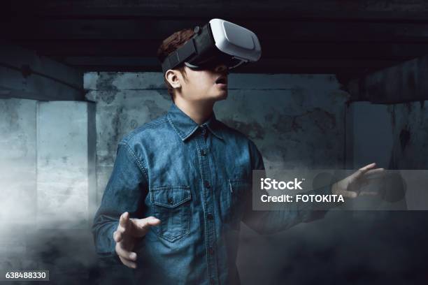 Man Using Virtual Reality Headset Stock Photo - Download Image Now - Virtual Reality, Virtual Reality Simulator, Dark