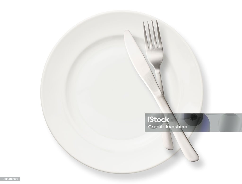 Isolated shot of white plate with cutlery on white background Overhead shot of white dinner plate with table knife and fork, isolated on white background. Plate Stock Photo