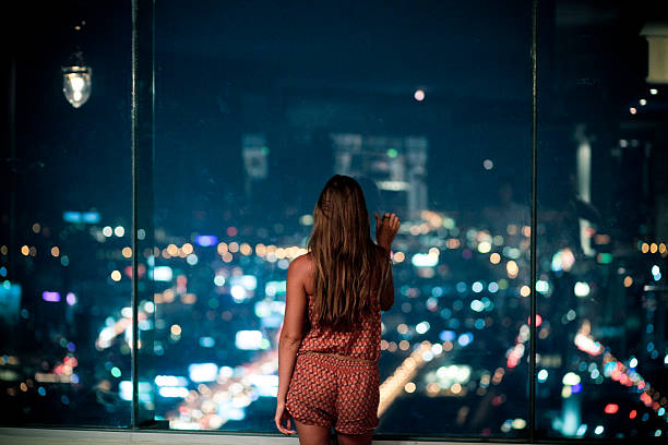 istock Woman watching the city at night 638489964