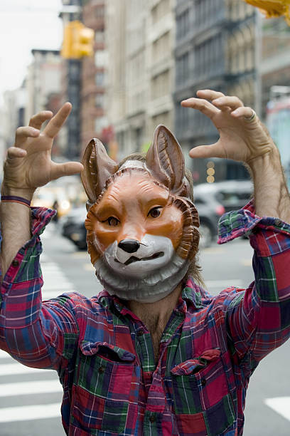 Man wearing fox mask acting silly in downtown city
