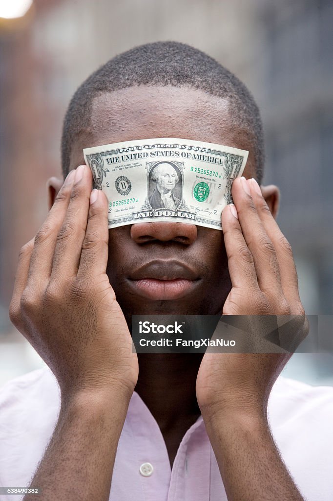Young man holding money over eyes Currency Stock Photo
