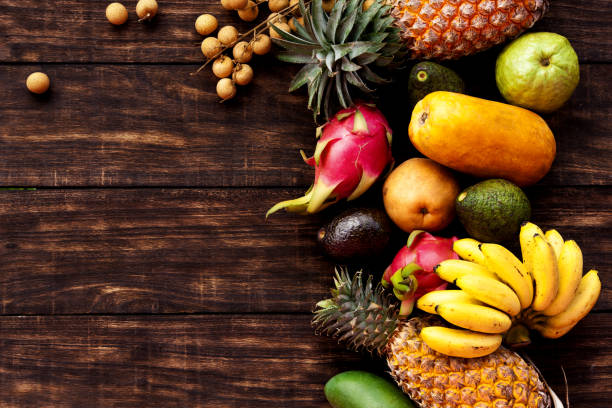 istock Tropical fruit on dark wooden background, top view 638490430
