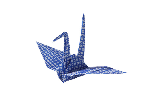 Blue dotted pattern origami paper crane on white background
