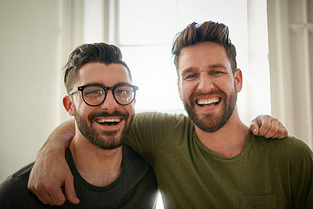 Brother's in business Portrait of two happy colleagues working together in a creative office sibling stock pictures, royalty-free photos & images