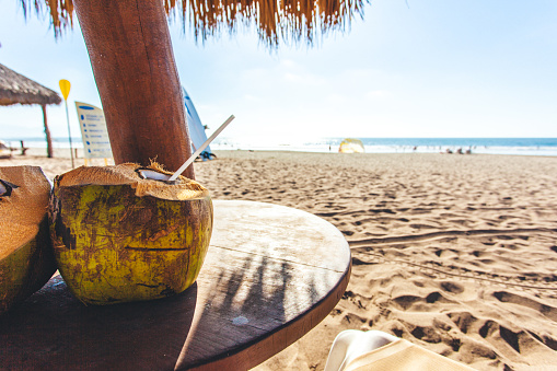 Coconut drinks on a table with a beach view.