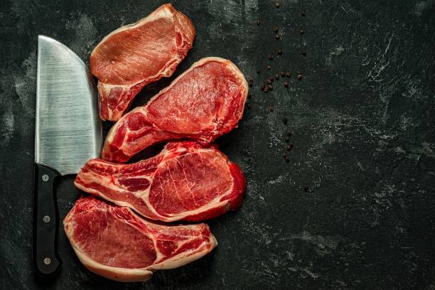 istock four raw pork steaks and kitchen knife 638495462