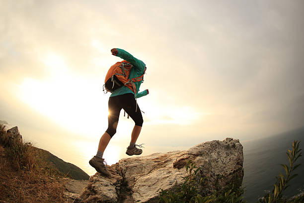 istock successful hiker running on seaside mountain peak 638495880
