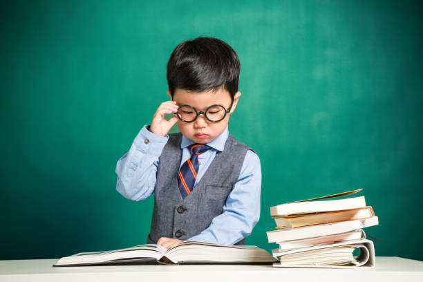 Little boy sitting at table and reading