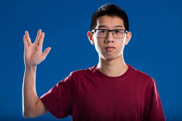 Photo of nerd trekkie salutation by an asian guy